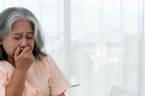 Woman coughing into her hand