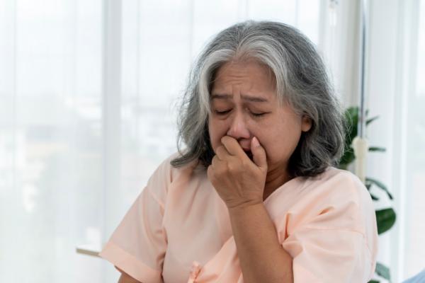 Older woman coughing with suspected COPD